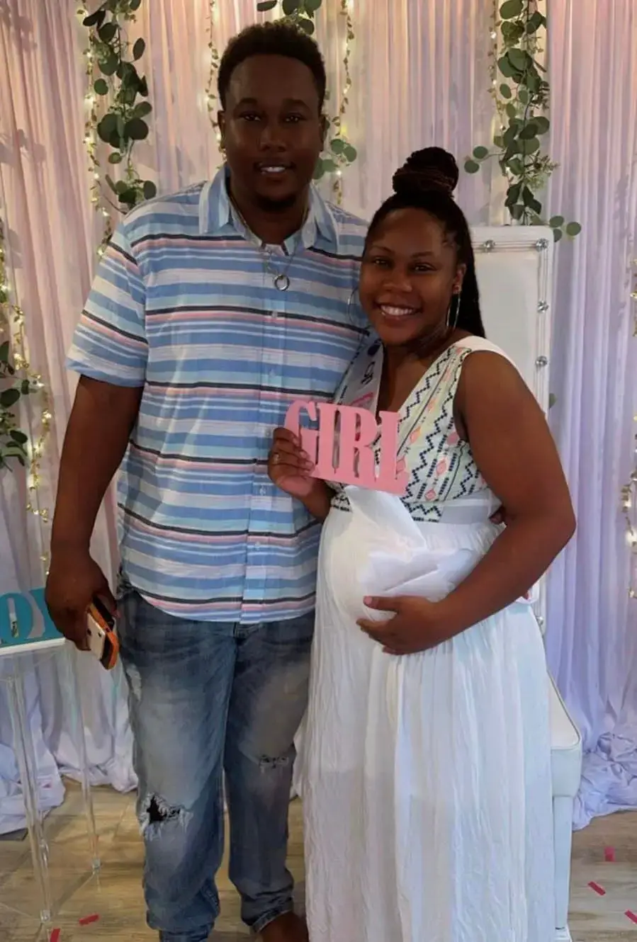 Regina Rawlins and her husband at their baby’s shower