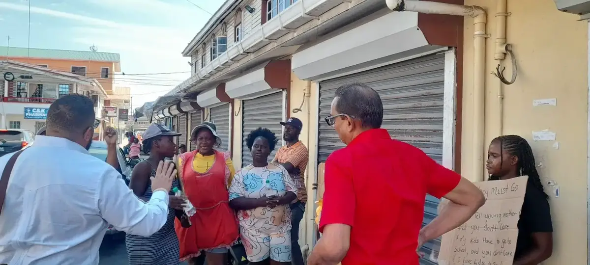 PPP/C councillors Alfonso DeArmas and Don Singh speaking with vendors outside the Kitty market building