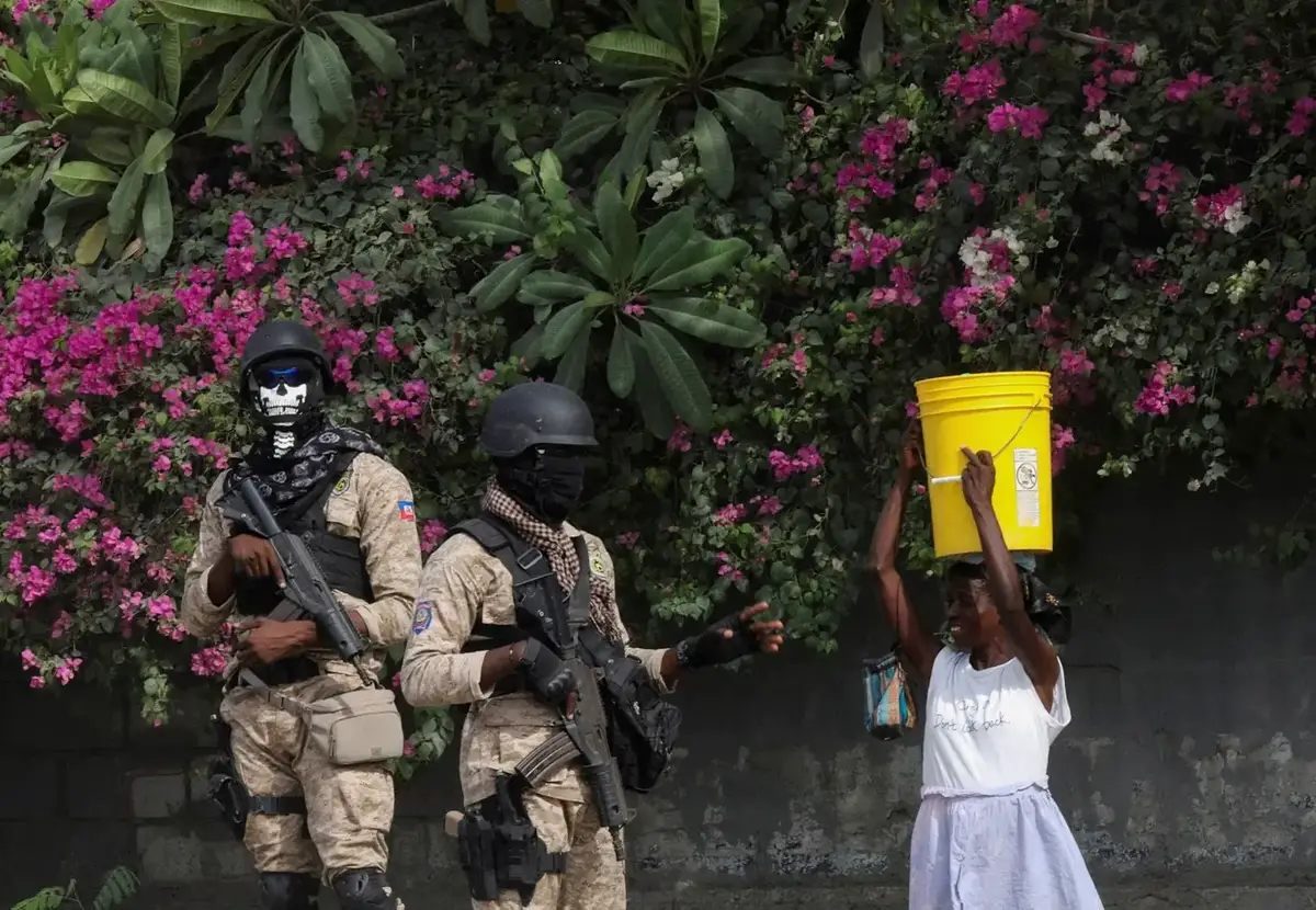 A Haiti an police officer talks to a woman while a fellow officer stands guard, in Port-au-Prince, Haiti, September 5, 2024. REUTERS/Ralph Tedy Erol/File Photo