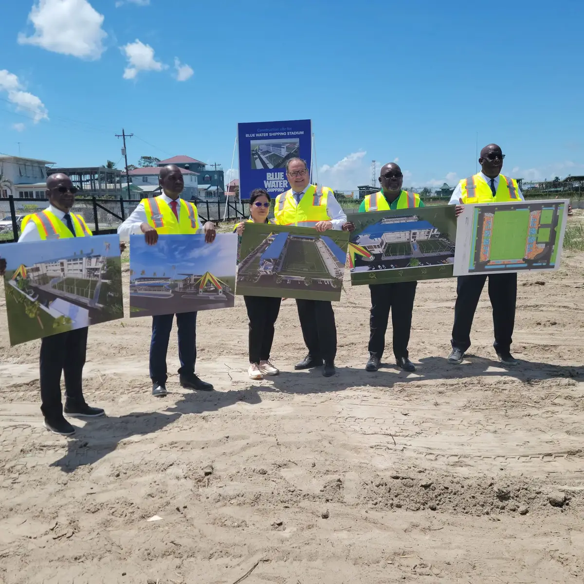 The delegation led by Concacaf President and FIFA Vice-President Victor Montagliani (4th from left) and GFF President Wayne Forde (2nd from left) displays an artist’s rendition of the facility after turning the sod for the Blue Water Shipping Stadium.