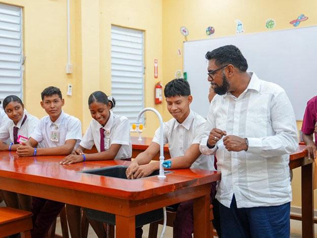 Engaging: President Irfaan Ali engages some students at the commissioning of a new state-of-the art North West Secondary School in Mabaruma. (Ministry of Education photo)