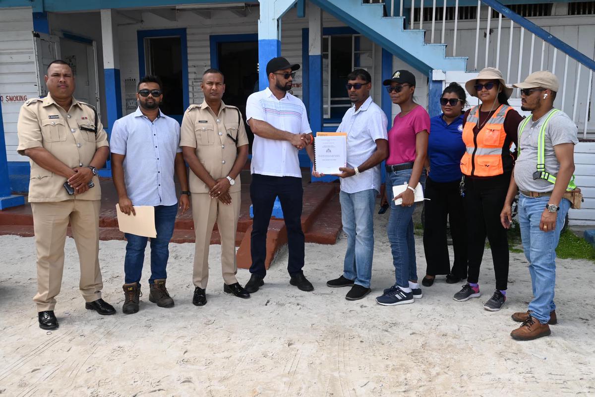 Permanent Secretary in the Ministry of Home Affairs, Andre Ally (sixth from right) handing over the contract for the Anna Regina Police Station to Builders Hardware, General Supplies, and Construction (Ministry of Home Affairs photo)