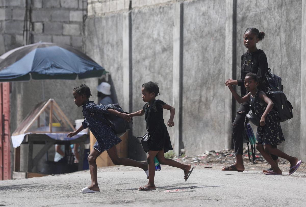 FILE PHOTO: A woman and three children flee their home from gang violence, in Port-au-Prince, Haiti October 20, 2024. REUTERS/Ralph Tedy Erol/File Photo