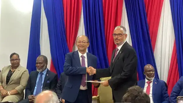 The president of the Transitional Presidential Council (CPT), Leslie Voltaire, on the left, officially hands over the certified copy of the decree to businessman Alix Didier Fils-Aimé, on the right, appointing him as Haiti's new Prime Minister, at the Villa d'Accueil in Port-au-Prince, on Monday, Nov. 11, 2024. Photo by Arnold Junior Pierre for The Haitian.