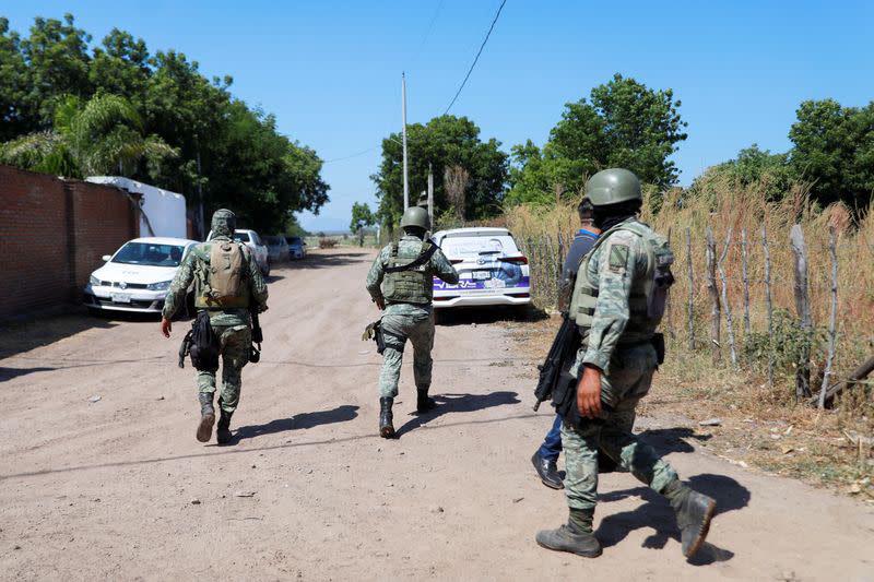 Federal forces guard the perimeter of a scene following a shootout, in Culiacan