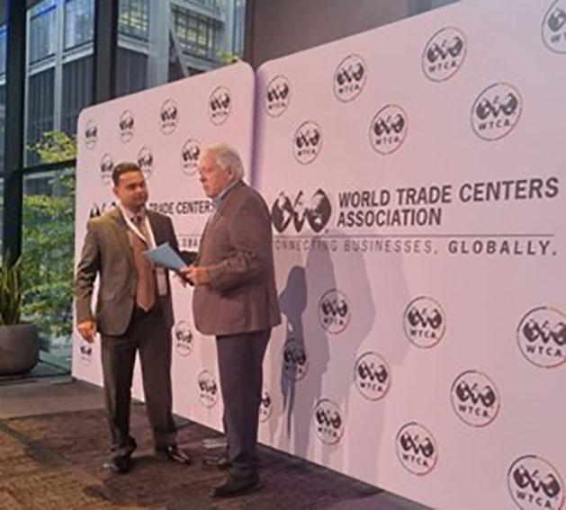 World Trade Center Georgetown Finance Director, Vasudeo Singh (left) presents a summary of the copyright study to World Trade Centers Association Chairman John Drew at the forum in New York