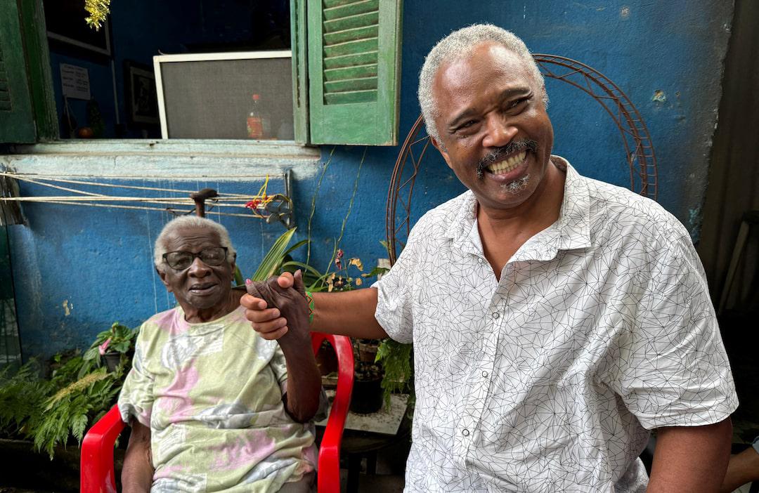 Helena da Costa, 99, holds hands with Dagoberto Jose Fonseca, 63, a professor at Sao Paulo's State University (UNESP) in Santos, Brazil December 5, 2024. REUTERS/Lais Morais