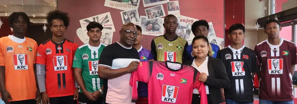 Tournament Administrator Troy Peters presents a team jersey to KFC Marketing Assistant
Charmaine Farnum in the presence of representatives from the competing schools, signifying the official start of the event.